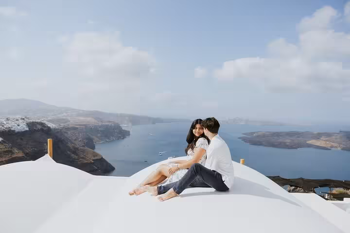 Couple on Santorini rooftop with caldera view during private honeymoon Instagram photo shooting island tour