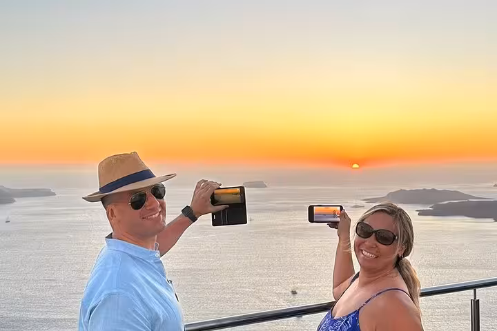 Couple captures Santorini caldera sunset while tasting local wine on the best views 2 wineries and tapas tour