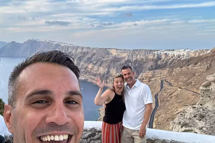 Happy couple at Santorini caldera viewpoint during private wine tasting and Wine Museum tour with winery visits