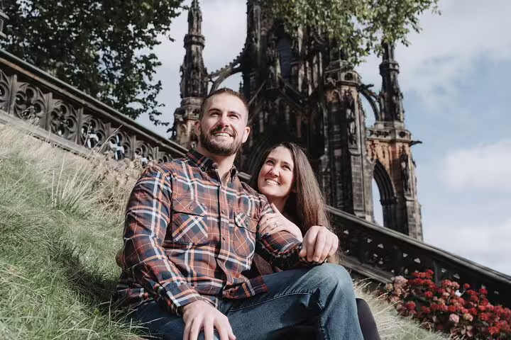 Couple sitting by Scott Monument in Edinburgh during private photoshoot with a professional photographer