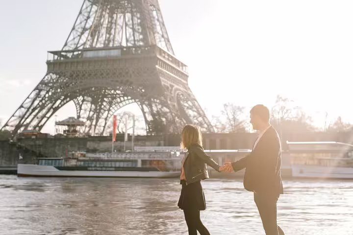 Couple holding hands by the Seine with Eiffel Tower view on a private Paris travel photographer tour