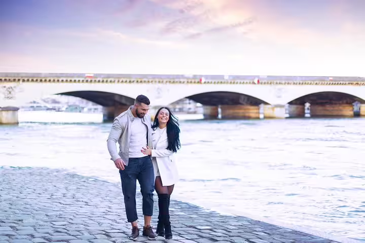 Couple strolling along the Seine in Paris, captured on a private travel photographer tour with bridge backdrop