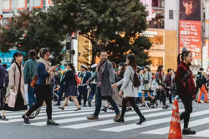 Couple crossing Shibuya Scramble in Tokyo during private photo tour, candid street photography with local guide