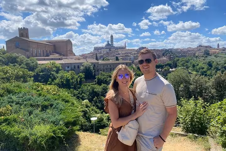 Couple enjoying panoramic views of Siena skyline on a sunny day during a small group tour in Tuscany.