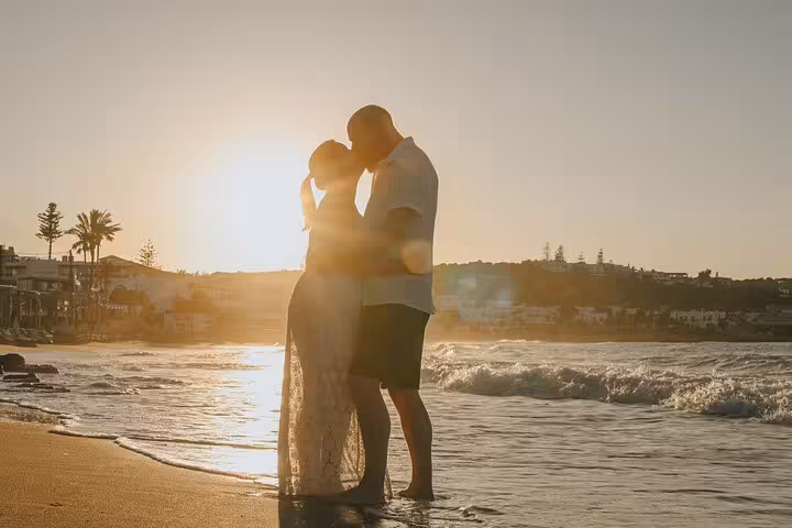Silhouette of couple embracing at sunset on Hersonissos beach for a private photoshoot experience.