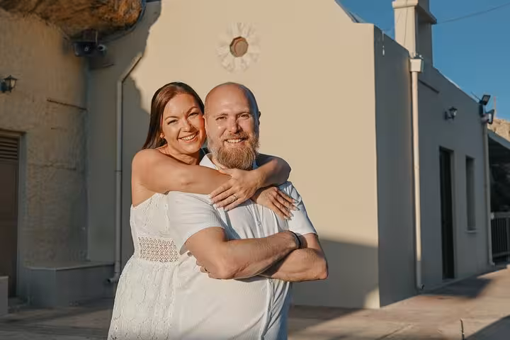 Happy couple embracing at sunset in Hersonissos during a private photoshoot, highlighting romantic travel experiences.