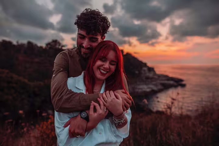 Couple sharing a tender moment at sunset during a professional photoshoot by the Naples coast.