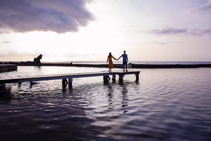 Couple holding hands on a pier at sunset during a private Tenerife photoshoot with a professional photographer