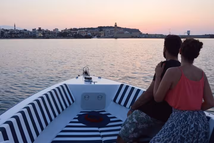 Couple on private yacht at dusk facing harbor skyline, romantic sunset private yacht cruise experience on calm sea
