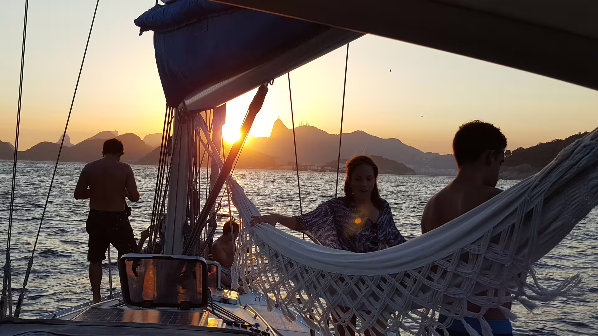 Couple relaxing on a yacht during a sunset sailing tour, admiring the stunning ocean view and coastal scenery.