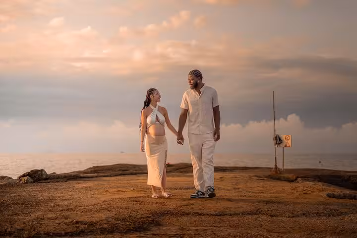 Couple walks hand in hand along Ammoudara's scenic coastline at sunset, creating a memorable photoshoot experience.