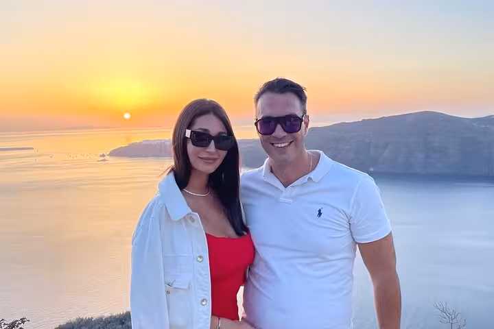 Couple posing at golden sunset during private wine tour, visiting 3 wineries with tapas and scenic caldera views