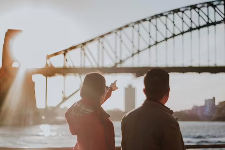 Couple at Sydney Harbour Bridge at sunset during private tour with personal travel photographer in Sydney