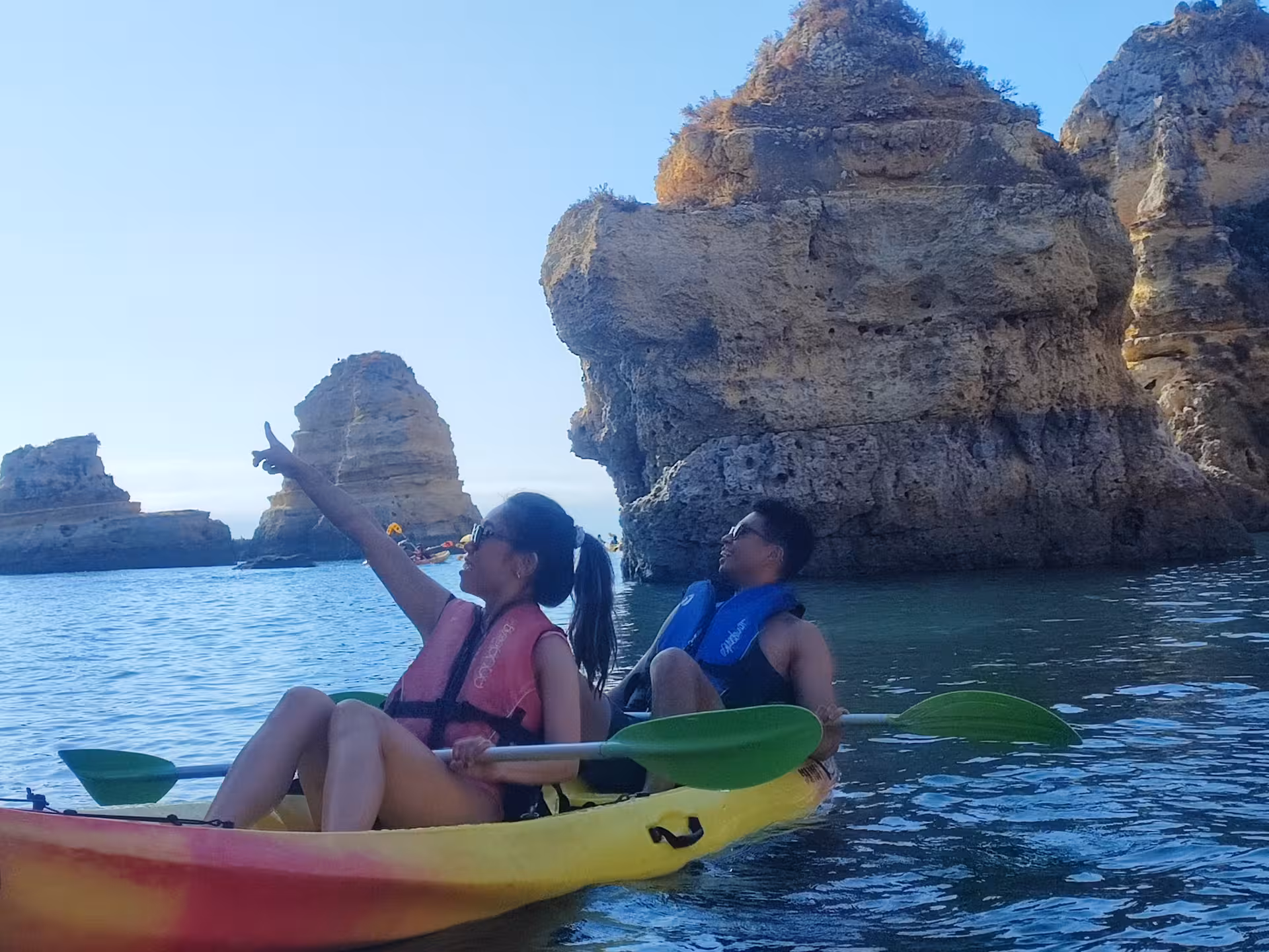 Couple in a tandem kayak explore Algarve sea caves and rock formations on a guided Portugal ocean tour