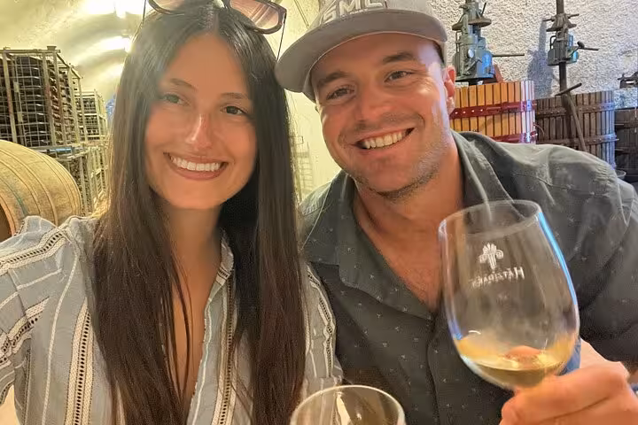 Couple tasting Santorini Assyrtiko in a cellar on a private wine tour at top wineries with local guide