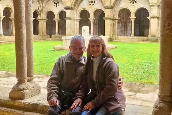 Couple enjoying a serene moment in the historic cloisters of Tomar during a private full-day tour from Lisbon to Tomar and Coimbra.