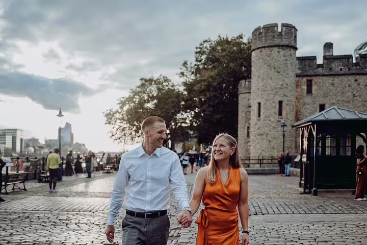 Smiling couple holding hands near the Tower of London on a picturesque private photography tour.