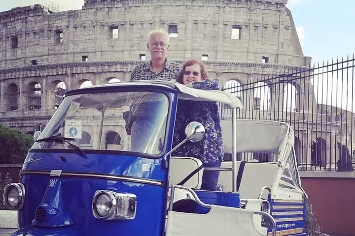 Couple enjoying a tuk-tuk ride near the Colosseum during a virtual tour experience in Rome.