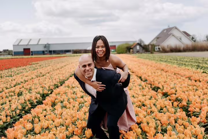 Couple laughing in Dutch tulip fields near Amsterdam, shot during a private travel and vacation photographer tour