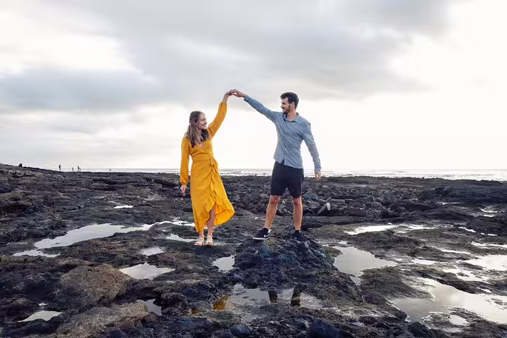 Couple twirling on Tenerife volcanic rocks at the coast during a private photoshoot with pro photographer