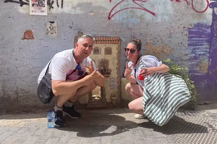 Couple crouching by mini mural during Valencia Iconic Sights scavenger hunt, fun old town challenge