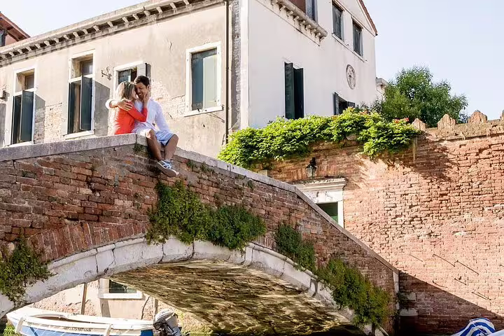 Couple embracing on a charming Venetian bridge during a private walking tour photo shoot.