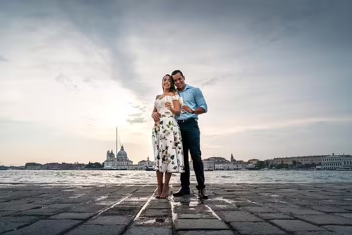 Smiling couple poses by Venice waterfront with scenic skyline during private walking tour photo shoot.