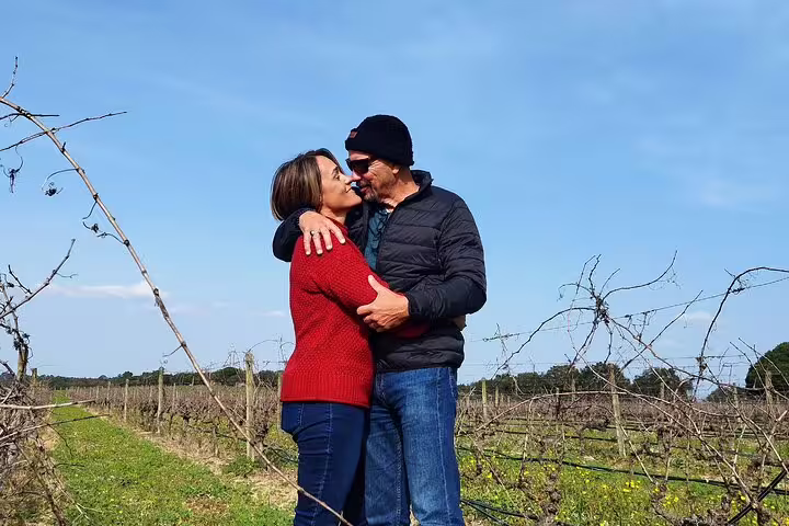 Couple embracing in a vineyard during a Private Tiles Painting Workshop, Wine Tasting, and Sesimbra Tour experience.