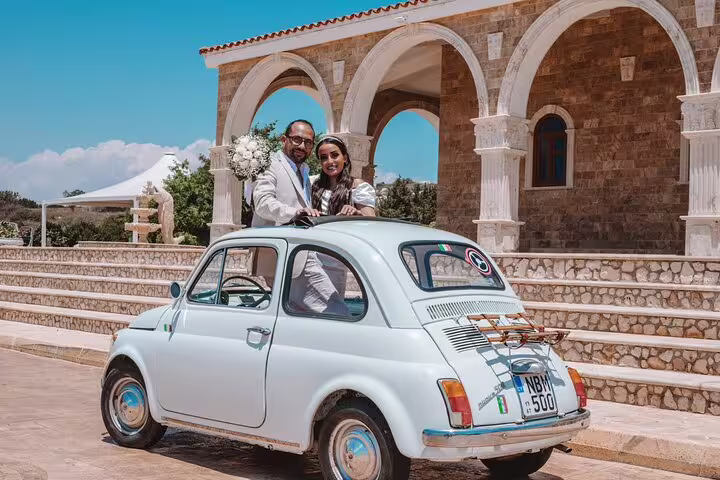 Couple poses in a vintage car outside a stone building during a private photoshoot in Ayia Napa.