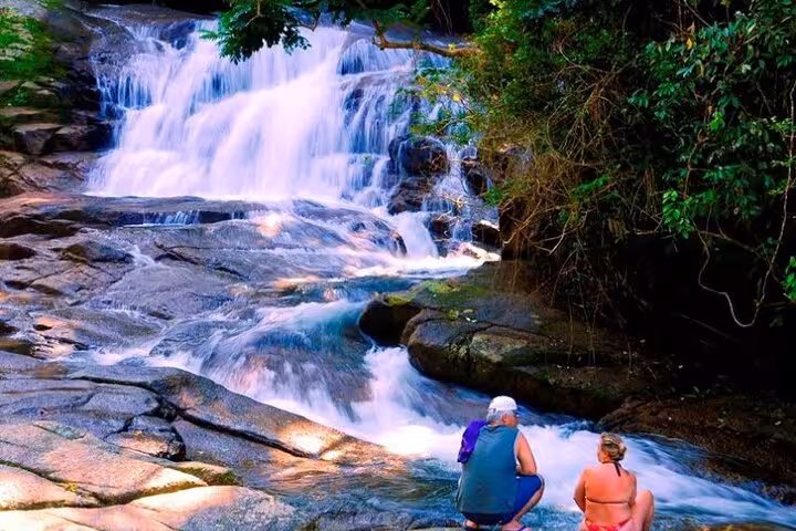 Couple admiring a stunning waterfall in the lush Paraty jungle during a private Jeep tour.