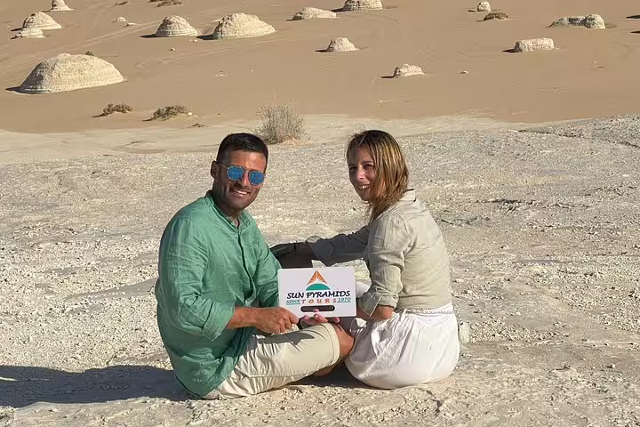 Couple seated on chalk rock plateau with White Desert formations, 3 days 2 nights Bahariya tour Egypt