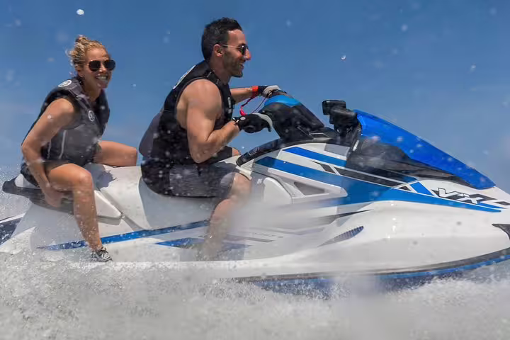 Smiling couple on Yamaha jet ski in Ibiza, action ride from San Antonio to Margaritas Islands