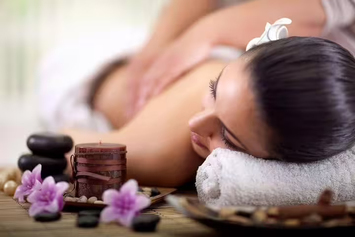 Spa setting with woman receiving full body massage, perfect 120-minute couples package with head and foot massage
