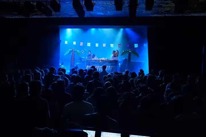 Crowded Cours Julien nightlife venue in Marseille with DJ set and blue lights, a stop on the district tour