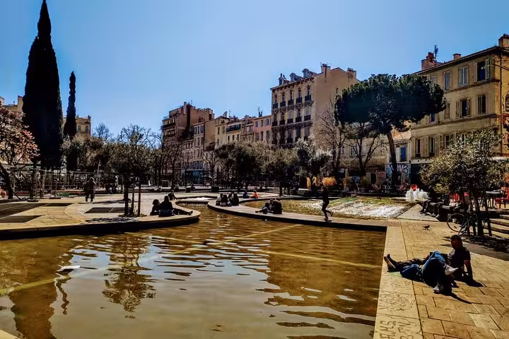 Sunny square by the water basin in Cours Julien, Marseille street scene near Noailles market tour stop