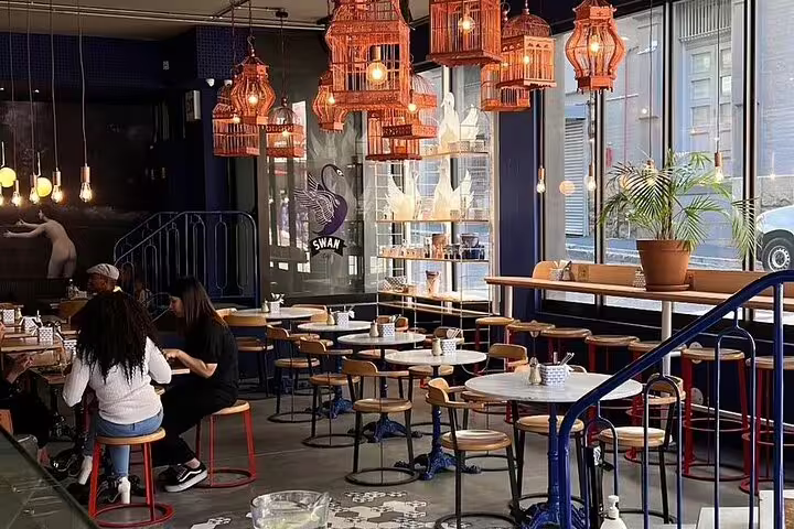 Cozy café interior with vibrant decor and birdcage lights, perfect for the start of a 3-hour culinary exploration tour.