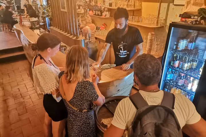 Guide pouring craft beer at a Marseille bar during a small-group beer tasting tour with local brews