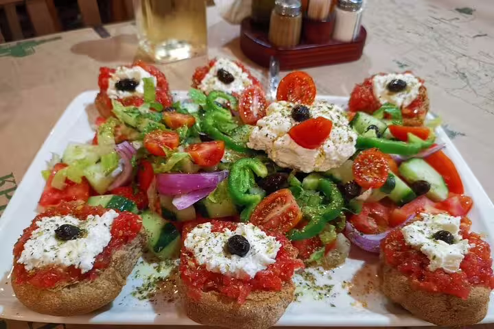 Vibrant Cretan salad with fresh vegetables, olives, and cheese, served on a rustic platter at a local taverna.