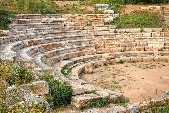 Ancient stone amphitheater with grass and wildflowers, a highlight of the Crete countryside private tour.