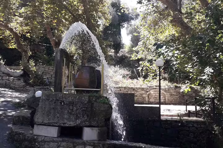 Picturesque stone fountain amidst lush greenery in the Crete countryside, perfect for a tranquil private tour.