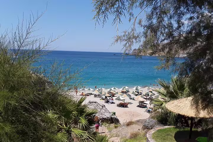 Idyllic Crete beach with turquoise waters and sun loungers, ideal for relaxation on the South Coast tour from Chania.
