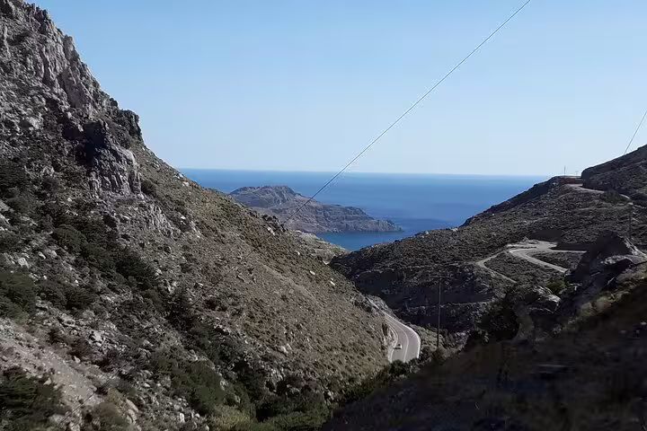 Breathtaking view of the winding road through Crete's mountains leading to the azure sea on the south coast.
