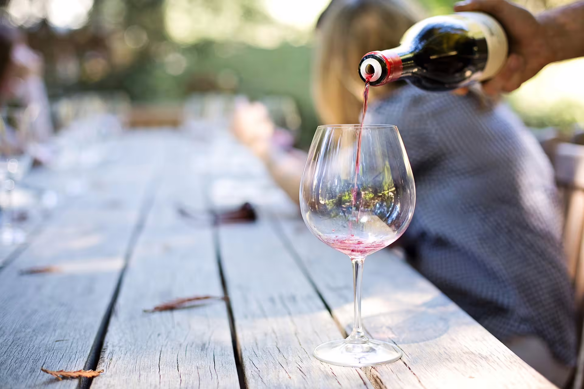 Close-up of red wine being poured into a glass during a private Crete vineyard tour, highlighting local wine culture.