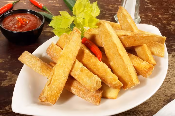 Crispy fried cassava served with spicy dipping sauce, showcasing traditional Bahian flavors in Salvador's cooking class.