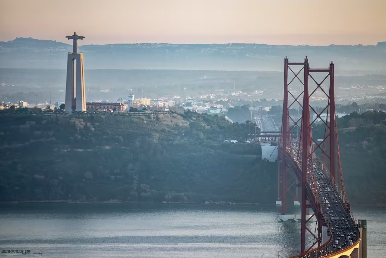 Panoramic view of the Cristo Rei statue and 25 de Abril Bridge in Lisbon, ideal for exploring on a classic tour.