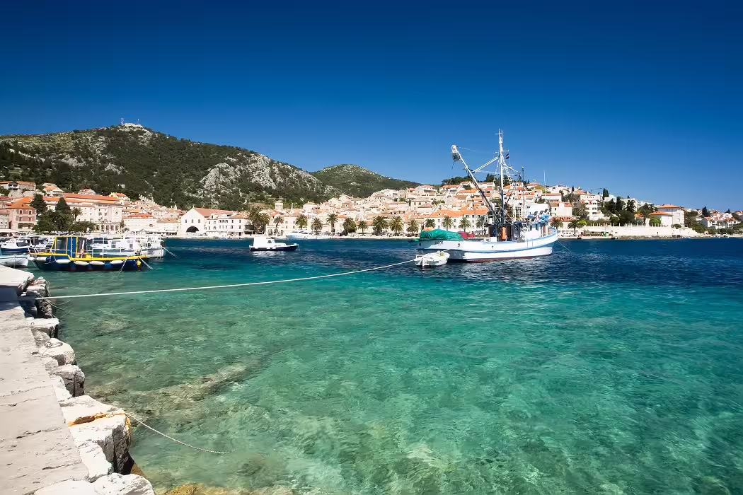 Crystal-clear Adriatic bay with fishing boat and coastal village, highlight of Croatia 11-day island hopping