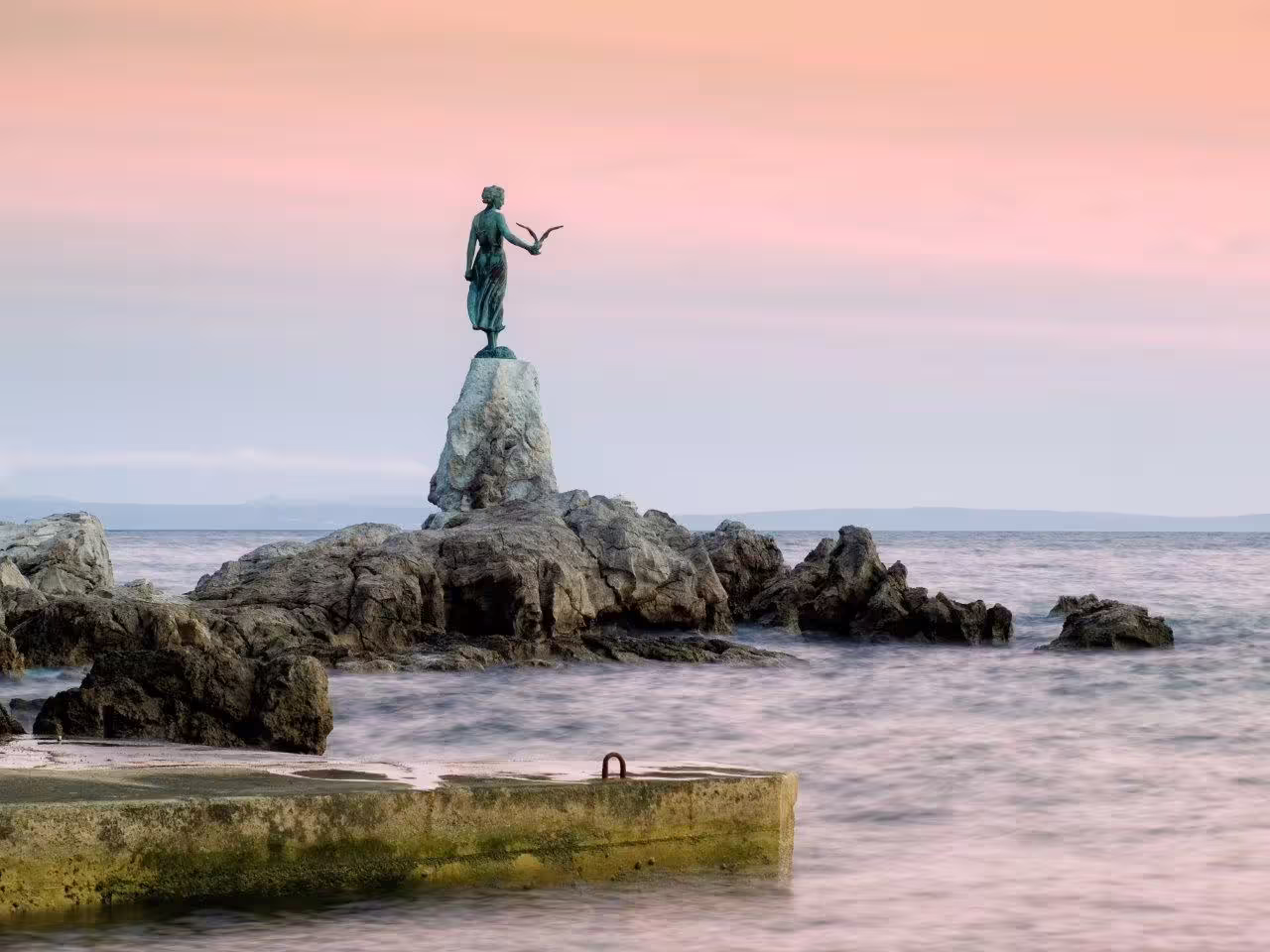 Opatija Girl with the Seagull statue on Adriatic rocks at sunset, Croatia self-drive coastal stop