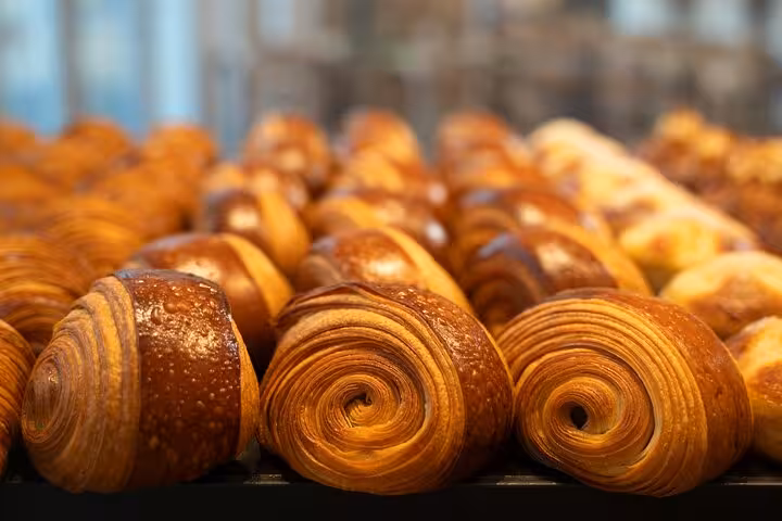 Rows of freshly baked croissants showcasing classic French pastries on a Le Marais food tour in Paris.