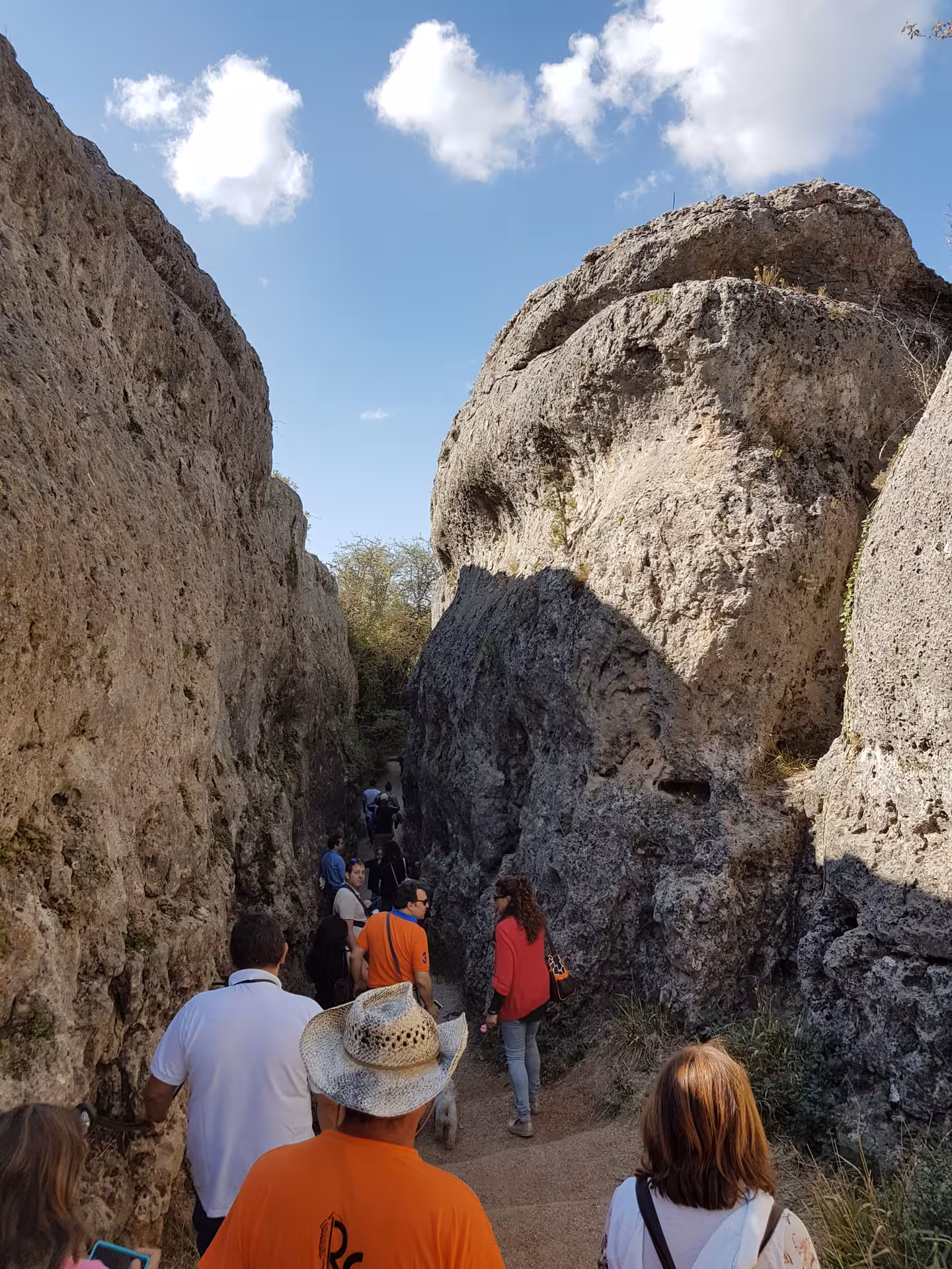 Hikers walking between limestone walls in the Enchanted City, Cuenca day tour from Madrid, Spain