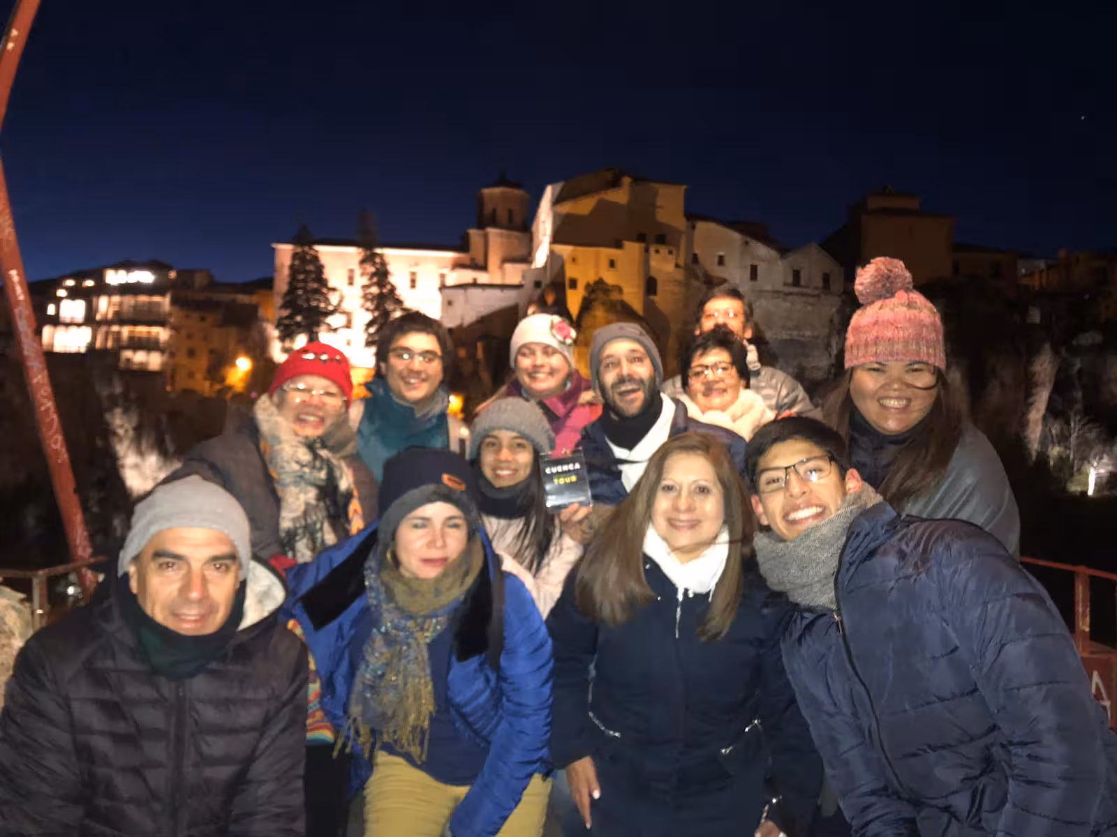 Tour group photo in illuminated Cuenca old town at night on a Cuenca and Enchanted City day trip from Madrid